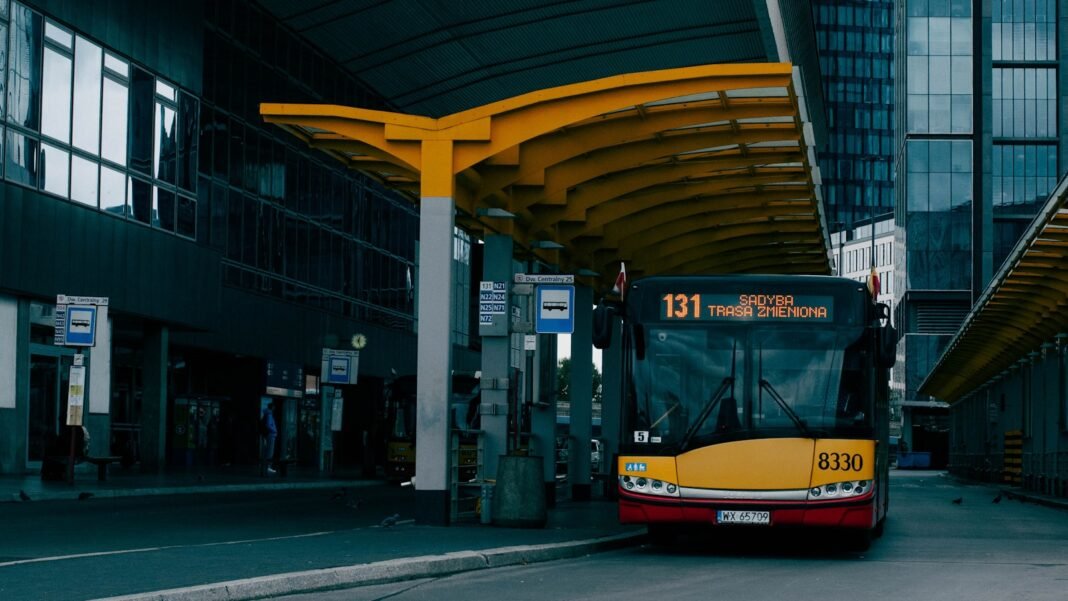 a yellow and red bus parked in front of a building