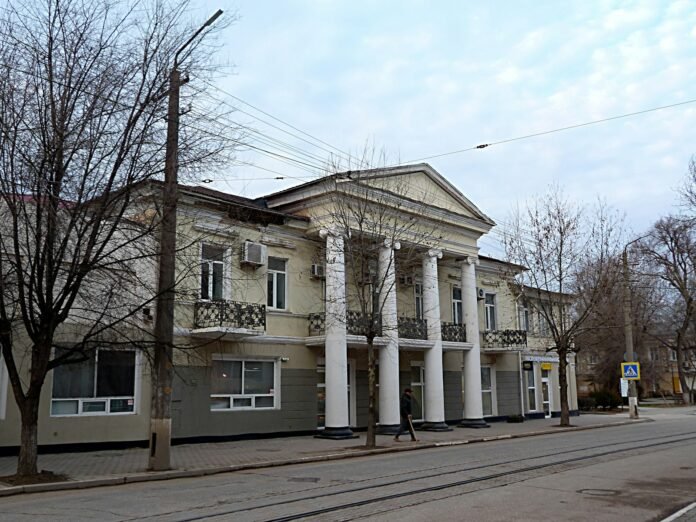 a building with columns and a clock on the front of it