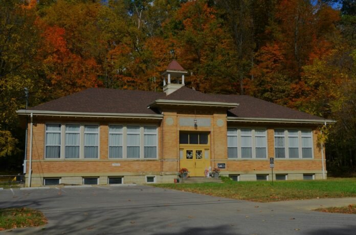 A school building with a clock tower in front of it