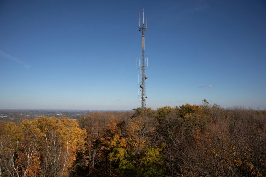 Photo by wisconsinpictures A tall cell tower stands on a wooded hilltop.