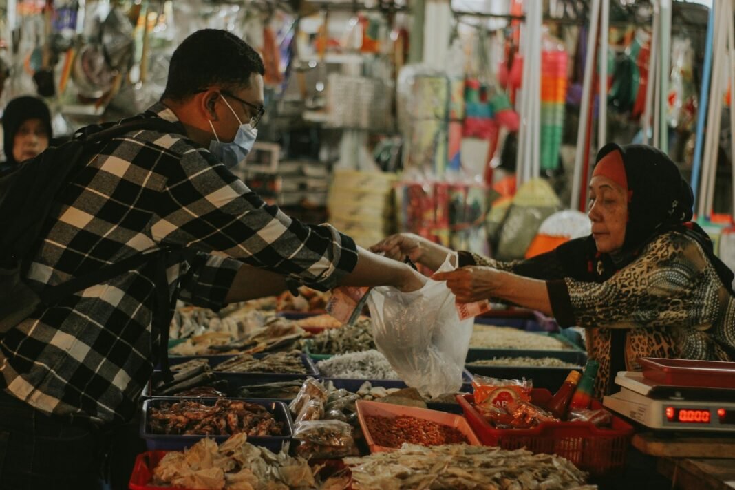 Photo by Falaq Lazuardi man in black and white plaid dress shirt holding white plastic bag