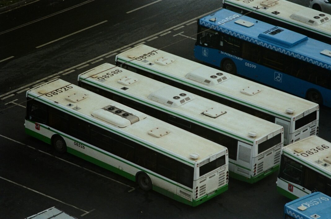 A group of buses parked next to each other in a parking lot