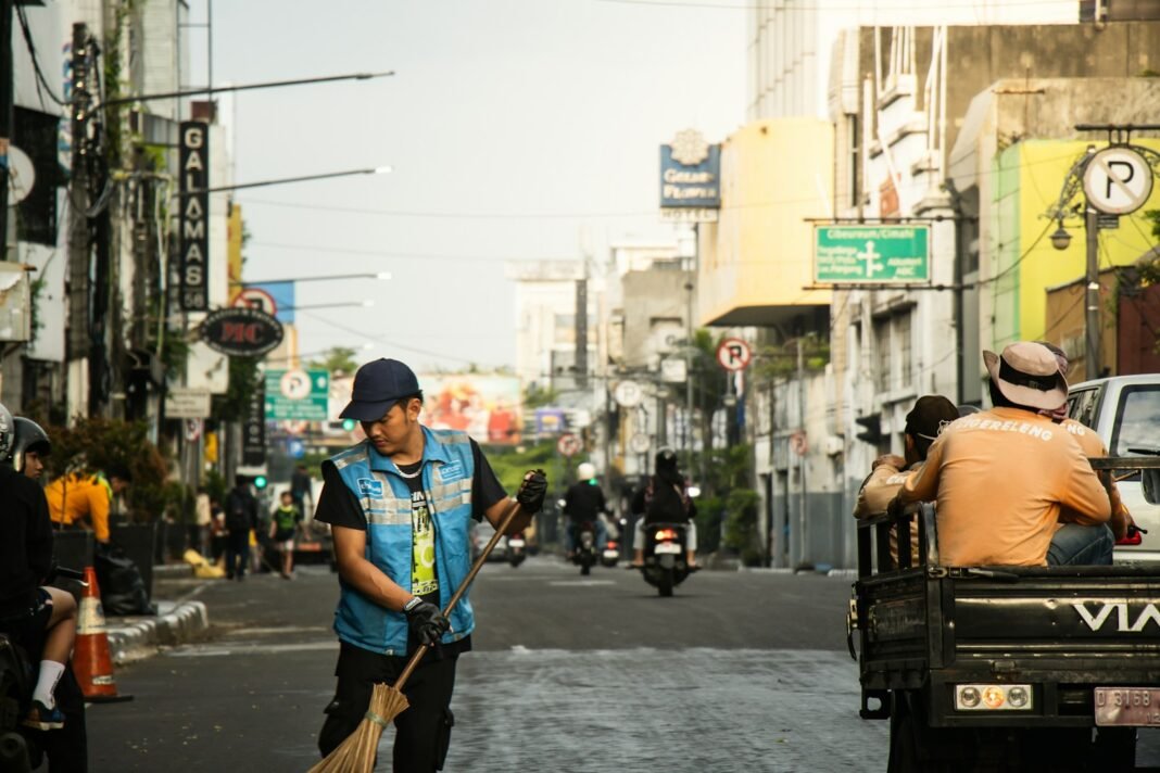 Photo by Abdul Ridwan Street cleaner sweeping a city road.
