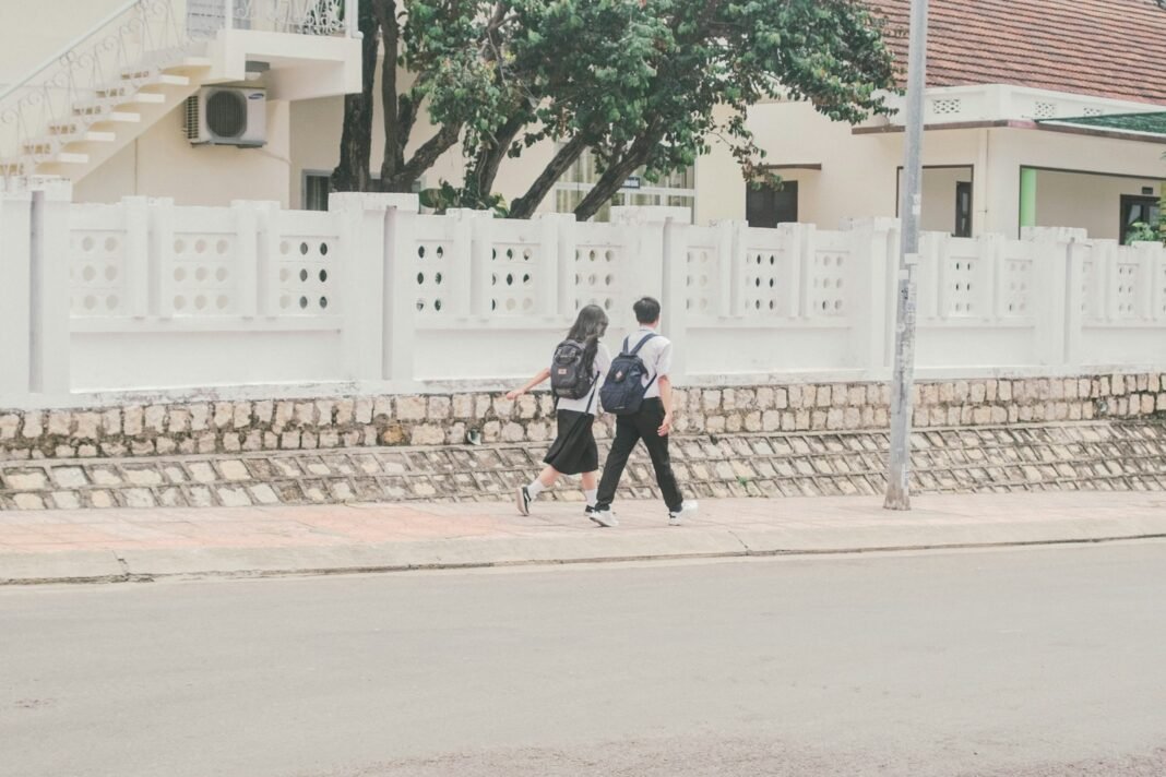 Photo by Phạm Trần Hoà n Thịnh a couple of people walking down a street