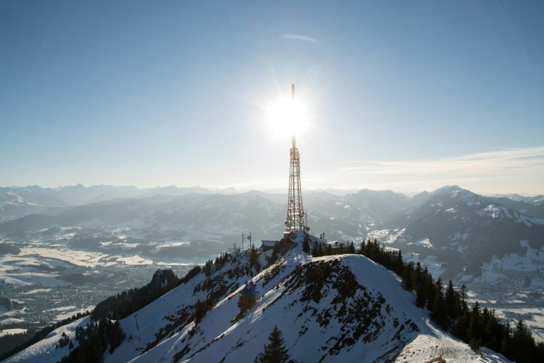 Photo by Nicole Kühn a very tall tower sitting on top of a snow covered mountain