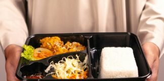 Suasana Hari Pertama Sekolah dengan Makanan Bergizi Gratis A person holds a bento box meal.