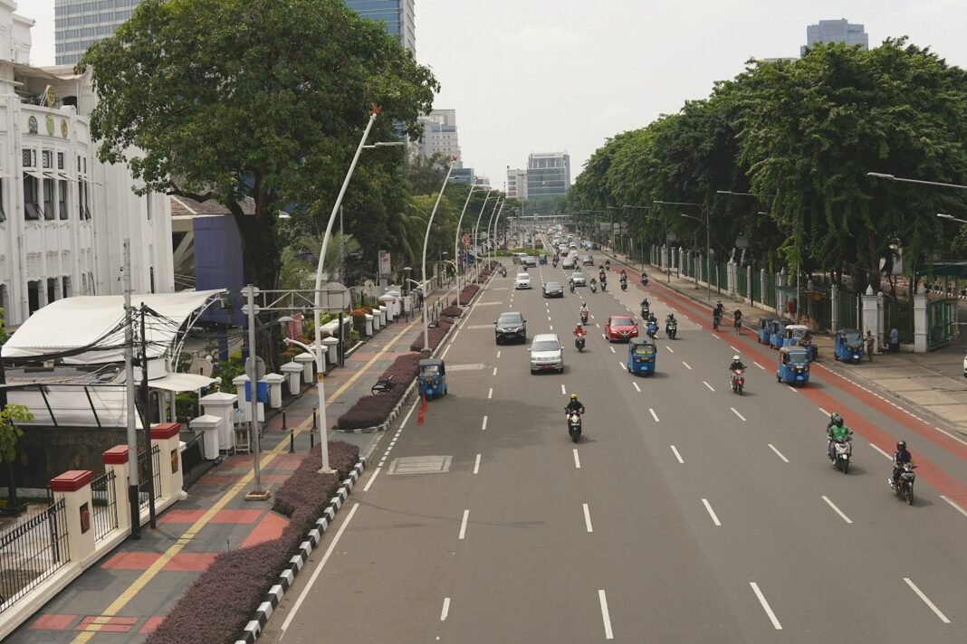 Photo by Alexander Nrjwolf a street filled with lots of traffic next to tall buildings